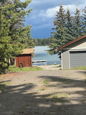 A lakeside property with a wooden shed, a garage, and a dock extending into the water. - Gorgeous Lakefront cabin, pet friendly! (Sheridan Lake)