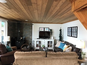 A cozy living room with a fireplace, a television, and a comfortable couch. - Gorgeous Lakefront cabin, pet friendly! (Sheridan Lake)