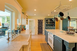 A kitchen with a large island, double sinks, and a built-in oven.