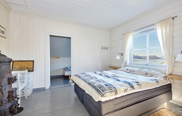 Un dormitorio con una cama grande, una ventana con vistas, un escritorio y una silla.