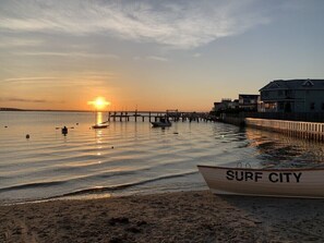 A beach scene with a wooden boat labeled "SURF CITY" and a pier extending into calm waters. - 4 Houses to THE BEACH! Completely renovated Duplex- 1st Floor- WALK TO ALL! (Surf City)