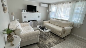 Ein modernes Wohnzimmer mit einem weißen Sofa, einem Couchtisch und einem Kamin.