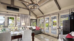 Un salón comedor amplio con techo alto, ventanas grandes y una zona de estar acogedora.