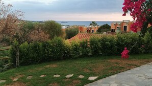 Un chemin de pierre menant à un bâtiment d’où l’on a une vue sur la mer.