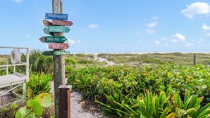 A wooden signpost with directional arrows pointing to various destinations such as Miami, Nassau, and Orlando.