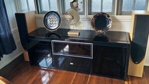 A modern kitchen with a black countertop, wooden cabinets, and a window with frosted glass. - At the Centre of Gallery Walk, Tamborine Mountain (Eagle Heights)