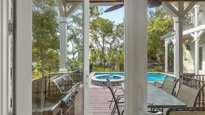 Un espace extérieur abrité comprenant une piscine, un barbecue et des sièges.