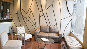 A modern lounge area with a sofa, armchairs, and a glass coffee table. - Hotel Las Lomas (Lima)