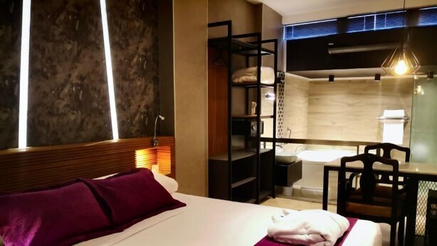 A hotel room with a bed, a desk, a chair, a bathroom, and a wardrobe. - Hotel Las Lomas (Lima)