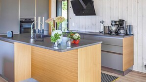 A modern kitchen with a central island, built-in appliances, and a large window. - Beautiful home in øyer with sauna (Øyer)