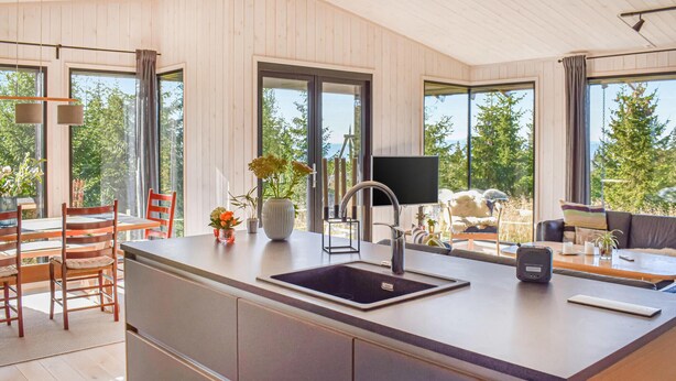 A modern kitchen with a central island, large windows, and a view of greenery. - Beautiful home in øyer with sauna (Øyer)