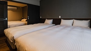 A hotel room with two beds, dark walls, and a wooden floor. - Ahman Inn Island Yagaji (Nago)