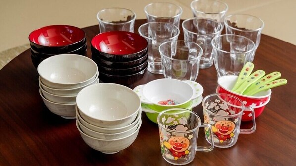 A variety of bowls and cups on a wooden table.