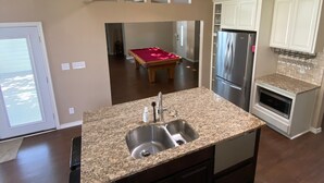 A kitchen with a granite countertop, stainless steel appliances, and a view to the dining area. - Quiet lakefront home. on Lake Leon, Eastland TX.  90 min to Fort Worth. (Eastland)