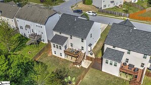 Un quartier résidentiel composé de plusieurs maisons, chacune ayant un jardin devant et une allée.