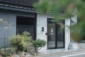 A modern building with a black door and a small sign above it. - someone, kyoto (Kyoto)