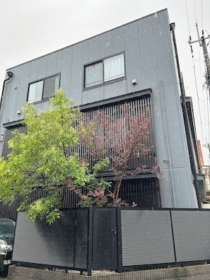 A modern building with a flat roof, two windows, and a black metal fence. - someone, kyoto (Kyoto)