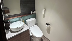 A modern bathroom with a large mirror, a sink, a toilet, and a shower area. - someone, kyoto (Kyoto)