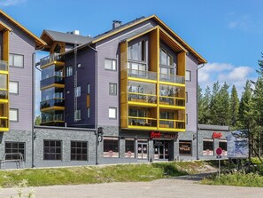 Un immeuble à plusieurs étages qui abrite un restaurant appelé « Wallis » au rez-de-chaussée.