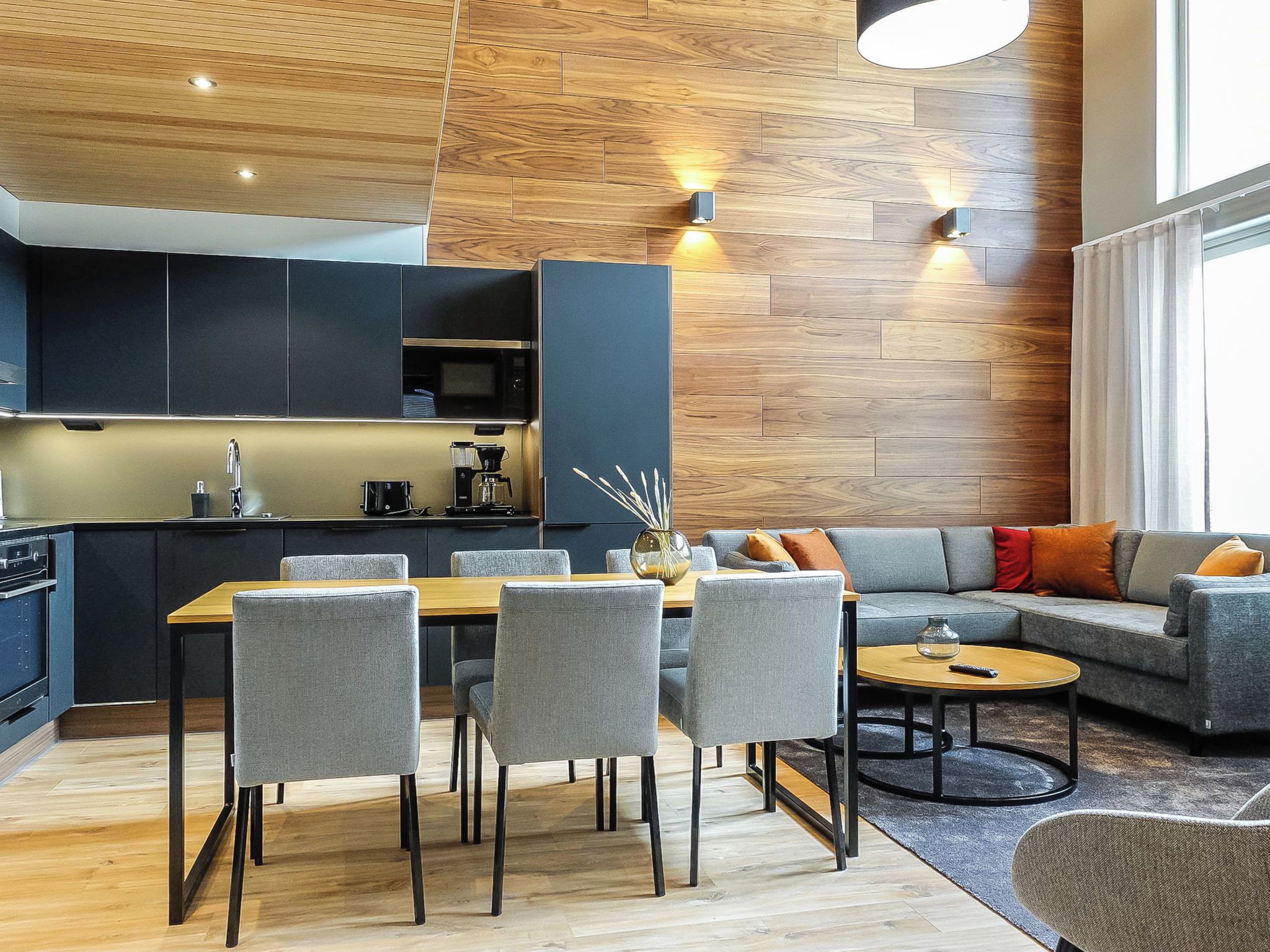 Un espace de vie moderne comprenant un coin repas, une cuisine et un espace détente.
