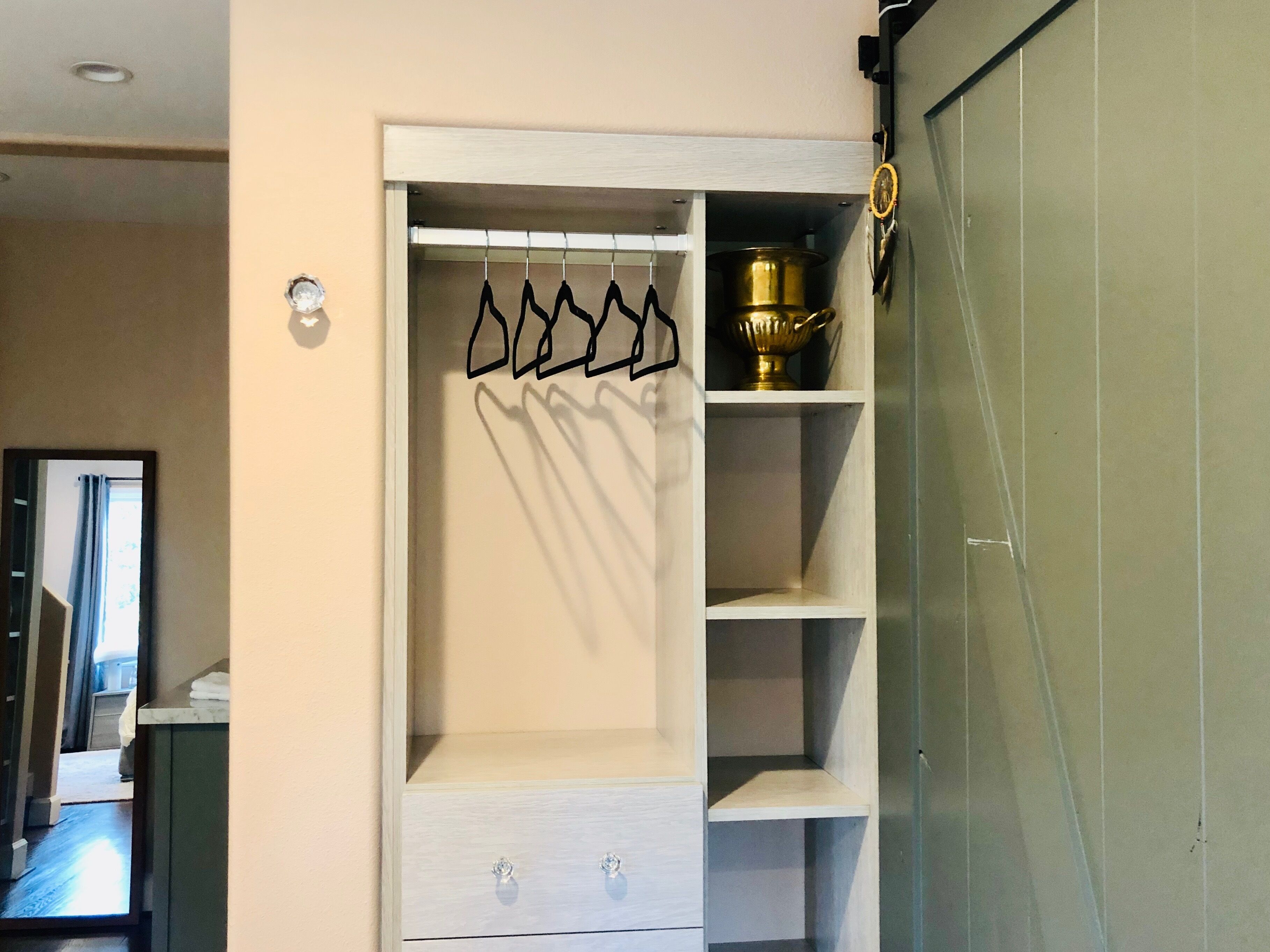 Un vestidor con una percha, estantes y un trofeo.