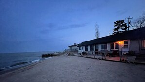 A beachside property with a house and a patio area. - #6 Two bedroom Dog friendly beachfront cabin. (Au Sable Township)