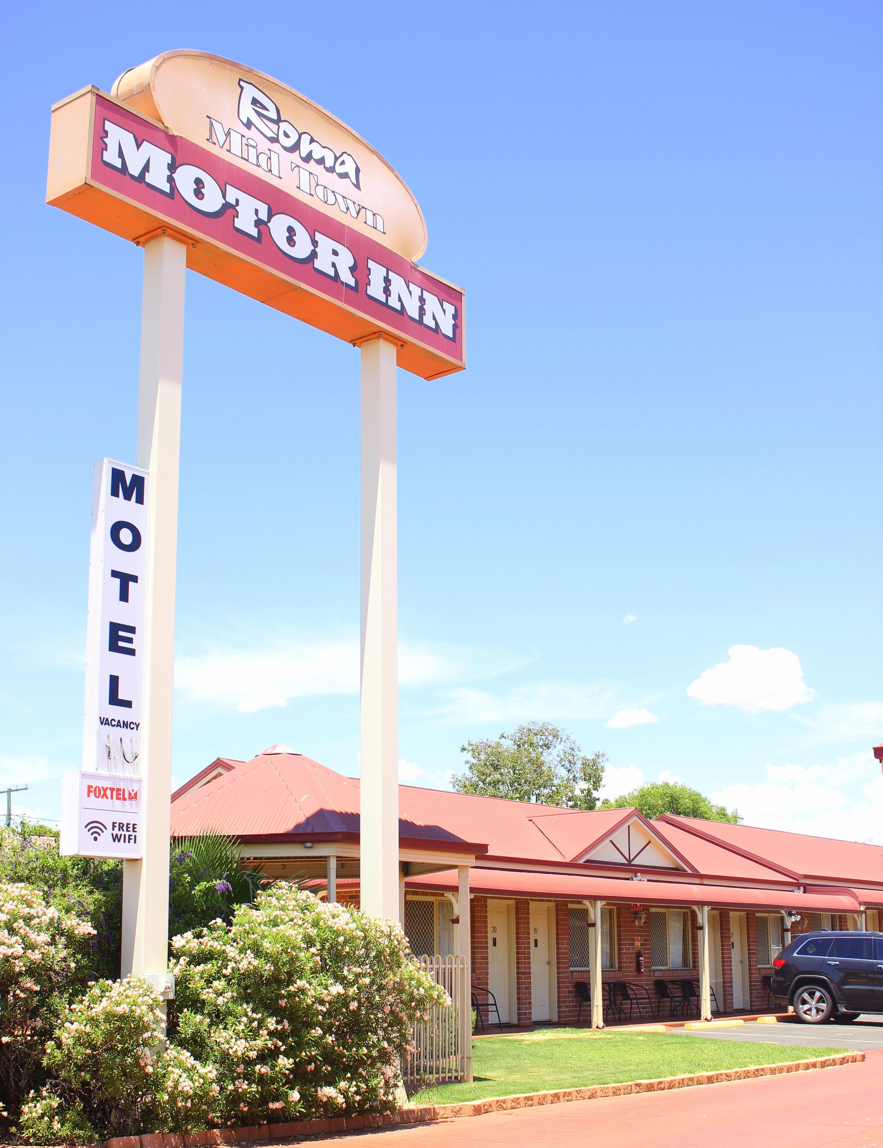 Señal de motel con techo rojo y letrero de motel.