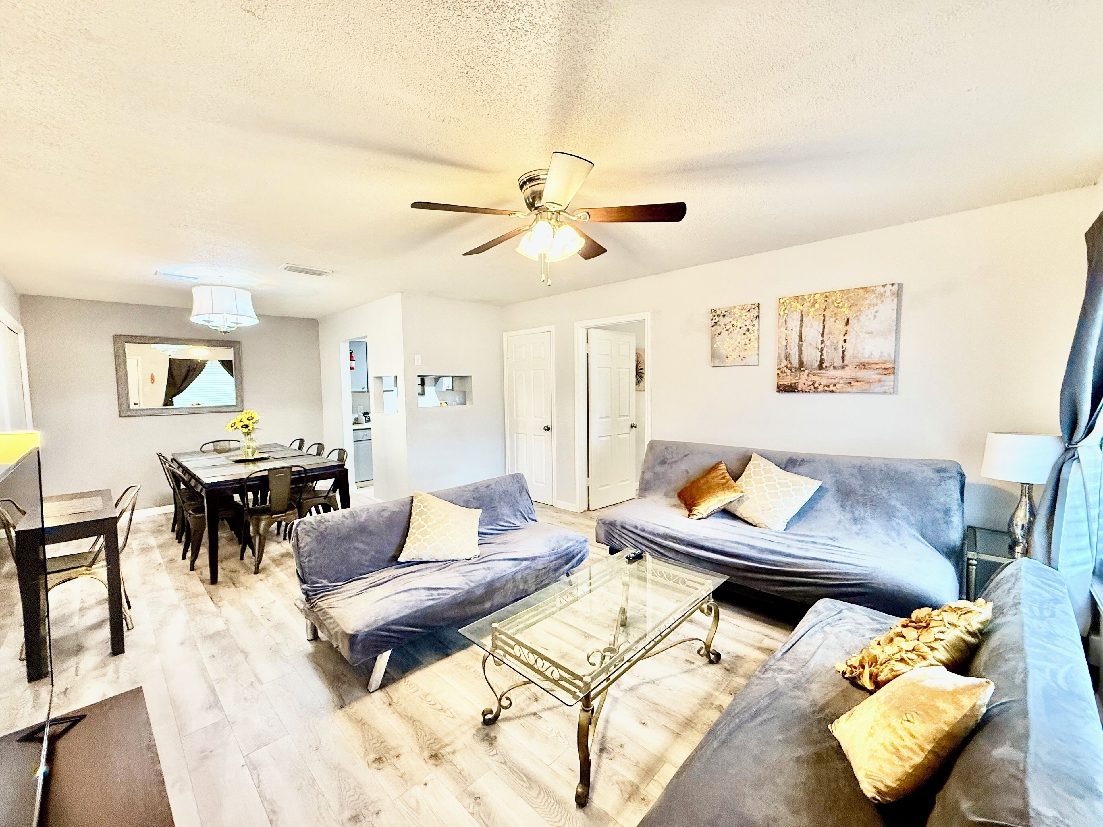 A living room with a sofa, coffee table, and dining area.