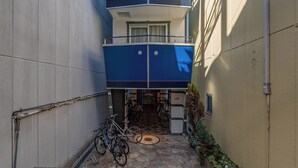 A narrow alleyway with a tall building featuring multiple balconies.