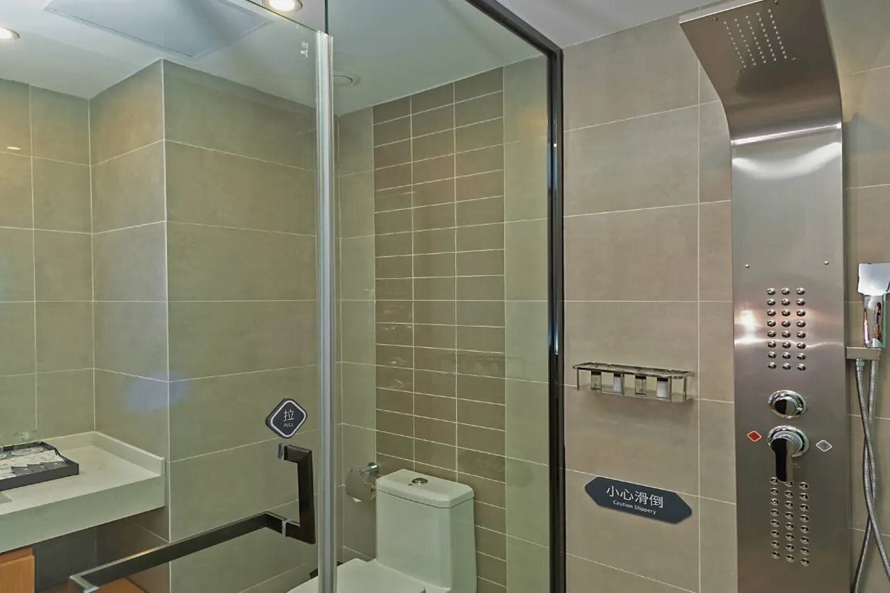Ein modernes Badezimmer mit Duschkabine, Toilette und Waschbecken mit Spiegel.
