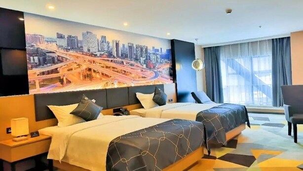 A hotel room with two beds, a cityscape mural on the wall, a large window with curtains, and a geometric-patterned carpet. - Chonpines Hotel (Guangyuan)