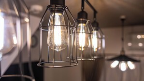 A series of hanging light fixtures with exposed bulbs. - Togano house Umeda central (Osaka)