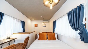 A bedroom with a bed, a desk, and chairs. - Togano house Umeda central (Osaka)