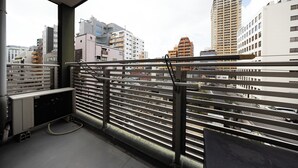 Ein Balkon mit Metallgeländern und Blick auf eine Skyline mit verschiedenen Gebäuden.