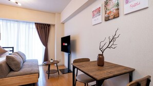 Ein modernes Wohnzimmer mit einer Couch, einem Holztisch und einem Fernseher.