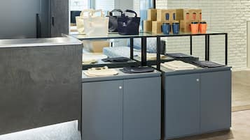 A reception desk with a glass display case containing bags and boxes.