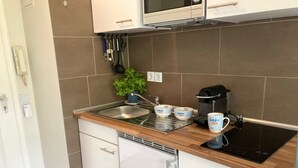 A modern kitchen with a built-in microwave, a coffee maker, and a sink.