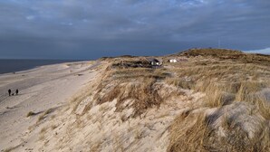 A sandy beach with dunes and a small building. - Lister Dünennest, Deutschland (List)