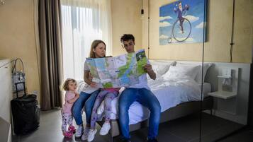 A hotel room with a bed, a map, and a painting on the wall.