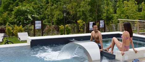 Una piscina al aire libre de temporada, tumbonas