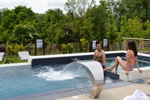 Una piscina al aire libre de temporada, tumbonas