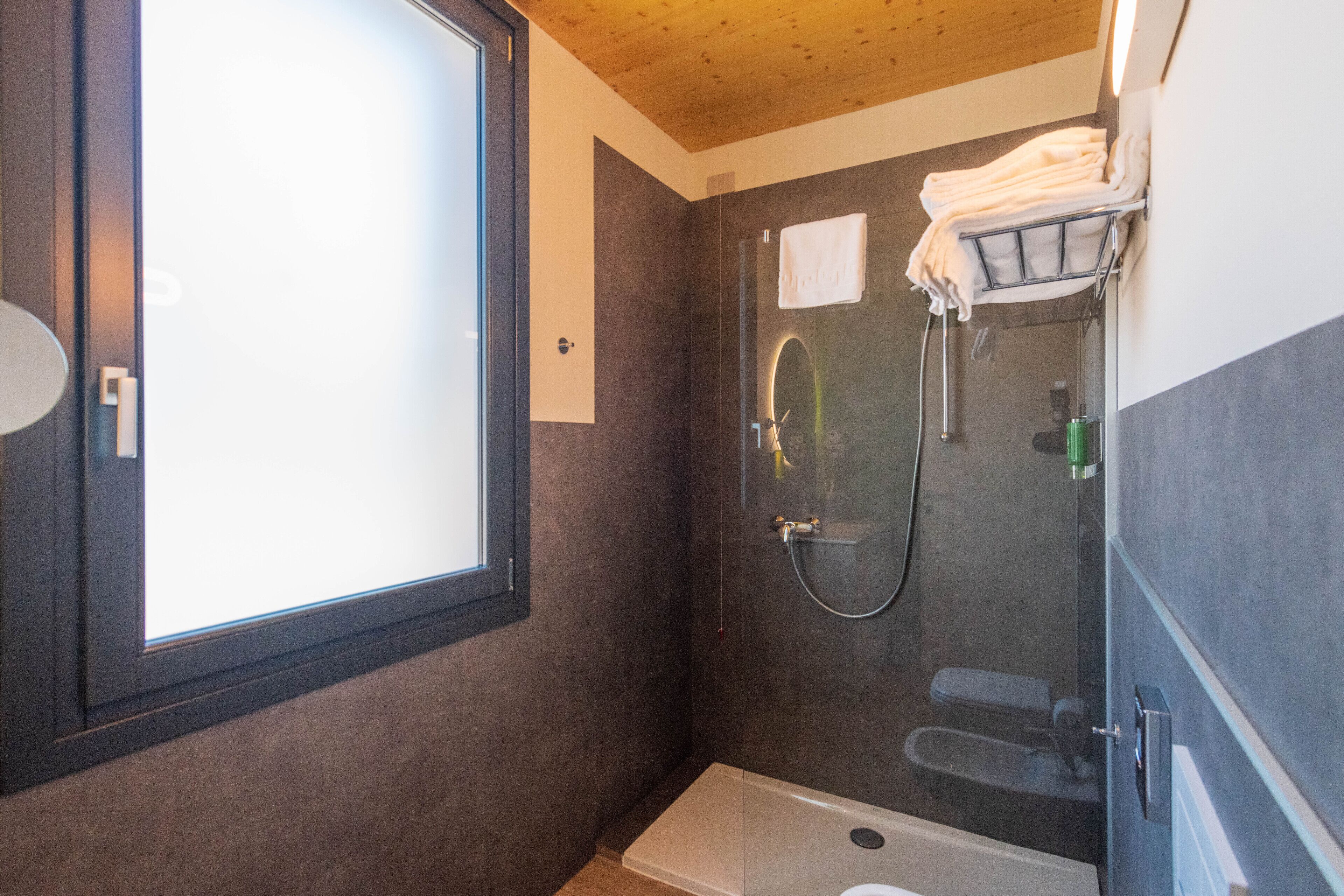 Un baño con bañera, ducha y ventana.