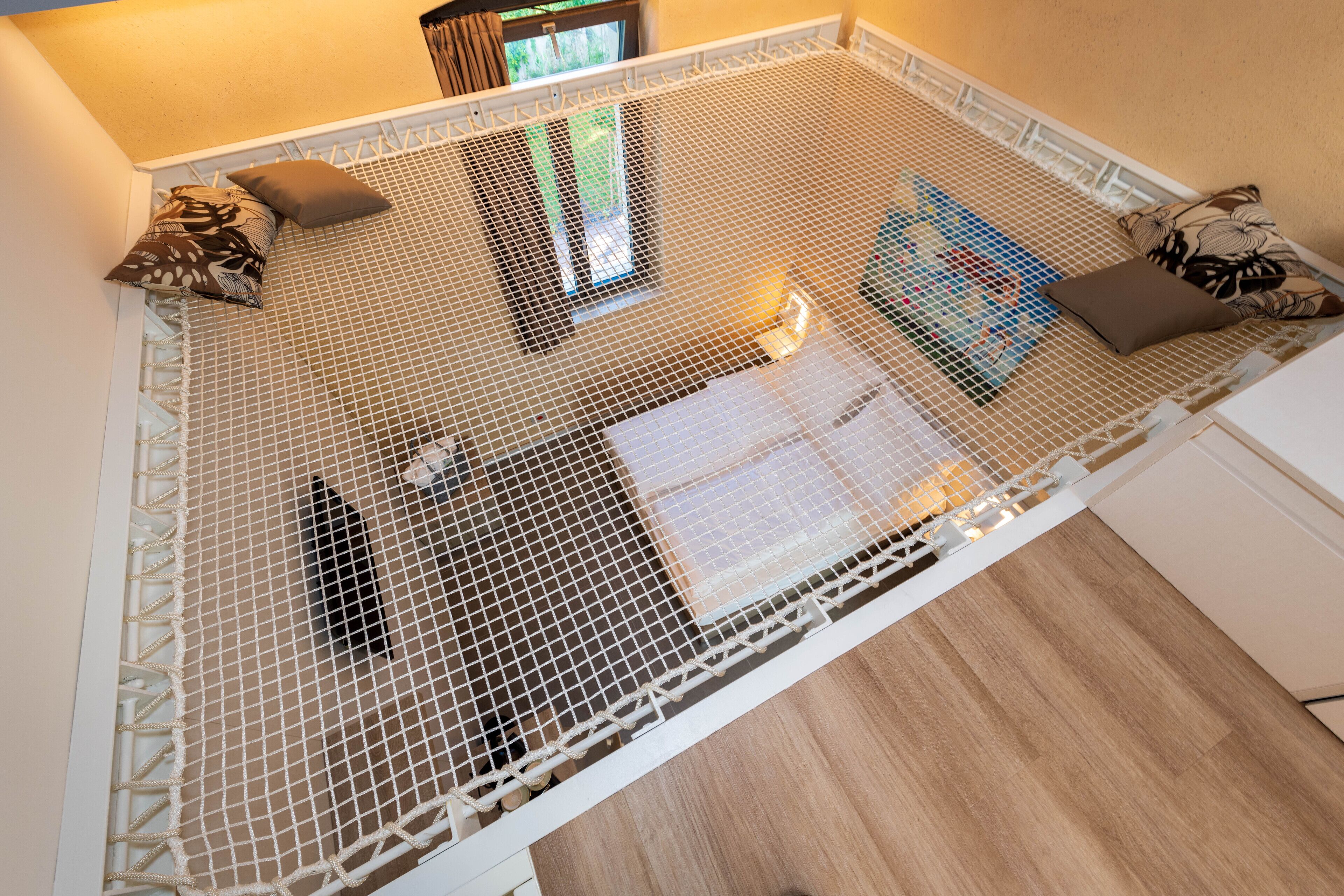 Una habitación con una cama blanca, cabecera blanca y protector de colchón blanco.