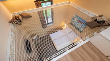 Una habitación con una cama blanca, cabecera blanca y protector de colchón blanco.