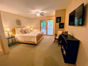 A bedroom with a bed, bedside lamps, a ceiling fan, a desk with a chair, and a TV on the wall. - O42 Renovated with high class upgrades! Ski access, boot warmer, ski rack, yard, AC, dog friendly! (Bretton Woods)