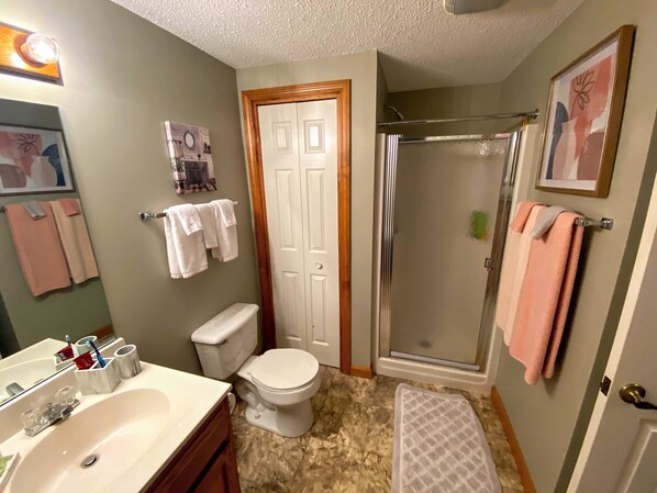 Un baño con lavamanos, inodoro y zona de ducha.