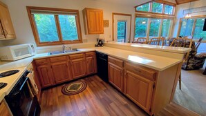 A kitchen with wooden cabinets, a microwave, a stove, and a dishwasher.