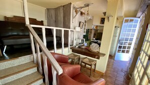 A staircase with a wooden handrail leading to a living area with a red leather sofa and a wooden table. - Provenc  beach house, breathtaking sea views pool , 5mn walk to beach  (Ensues la redonne)