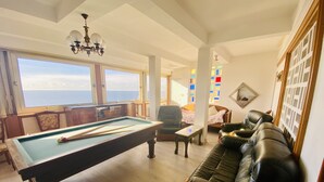 A pool table with pool cues, a leather sofa, and a view of the sea through large windows. - Provenc  beach house, breathtaking sea views pool , 5mn walk to beach  (Ensues la redonne)