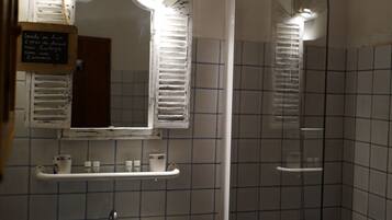 Un bagno con lavandino, specchio e doccia.